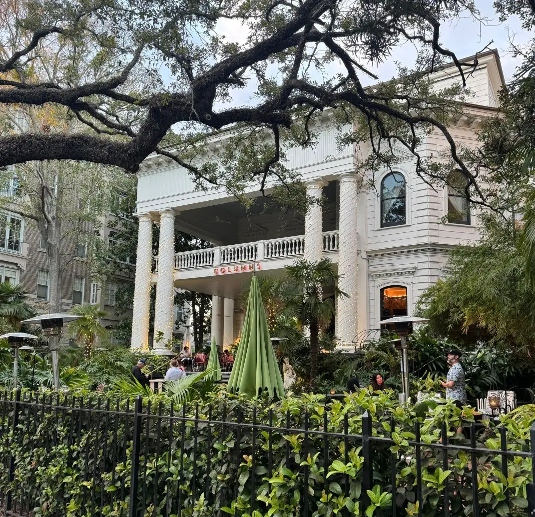 Exterior of The Columns Hotel in New Orleans with iconic white columns and lush garden