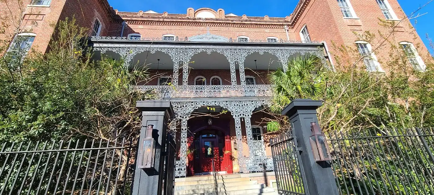 Exterior of Hotel Saint Vincent in New Orleans with ornate wrought-iron balconies and red brick facade