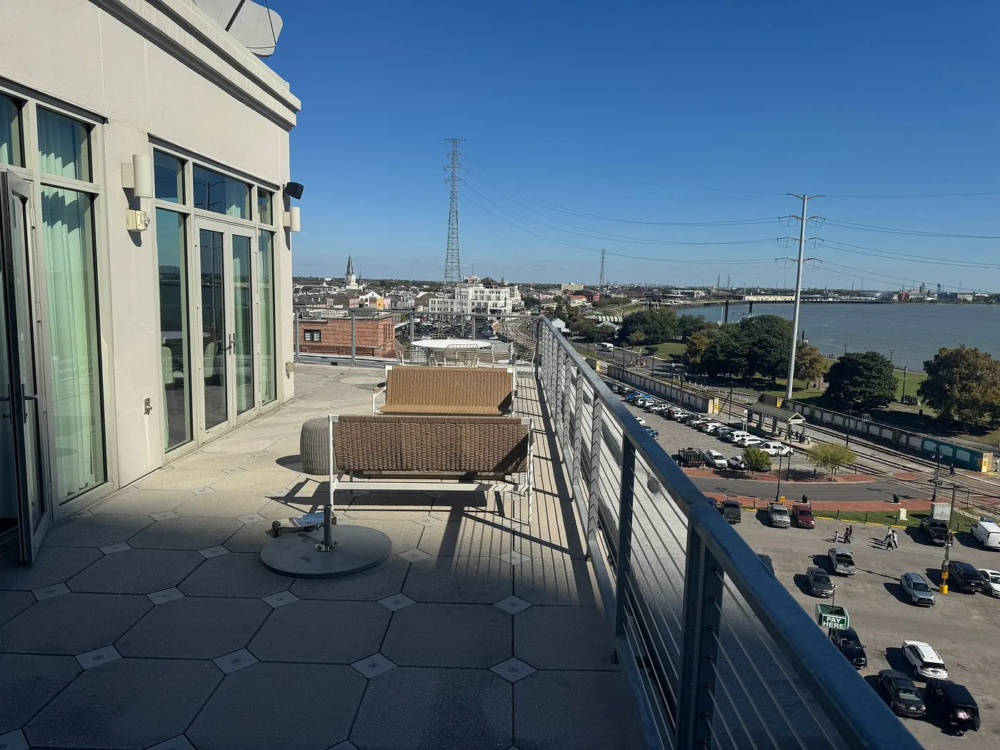 Spacious private terrace at One11 Hotel with wicker seating and panoramic views of the Mississippi River and French Quarter skyline